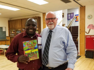 Michael holding book Daylight children have written with Pastor Howard edited